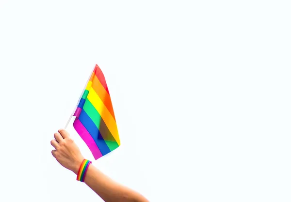 空に虹の旗をつけたゲイのプライドブレスレットを手に Lgbtの人々 同性間の関係 同性愛の概念 ロイヤリティフリーのストック写真
