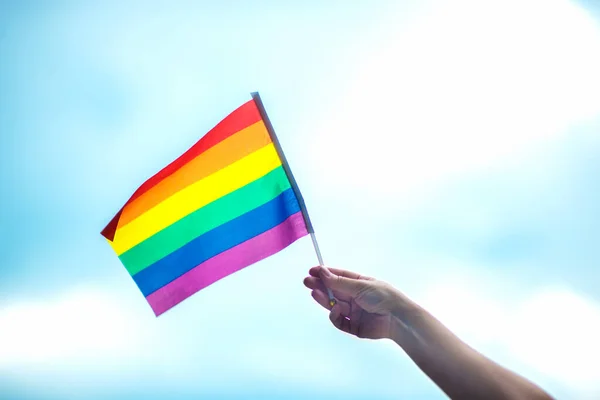 空に虹の旗をつけたゲイのプライドブレスレットを手に Lgbtの人々 同性間の関係 同性愛の概念 — ストック写真