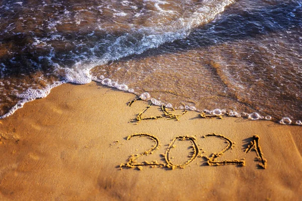 Deniz kenarında mutlu yıllar 2021 metinleri. Seçici odaklanma. Yaklaşan Yeni Yıl 2021 ve giden 2020 'nin soyut arkaplan fotoğrafları