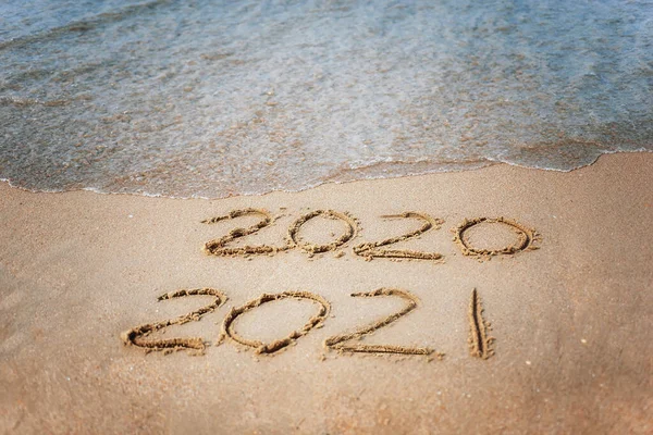 Deniz kenarında mutlu yıllar 2021 metinleri. Seçici odaklanma. Yaklaşan Yeni Yıl 2021 ve giden 2020 'nin soyut arkaplan fotoğrafları