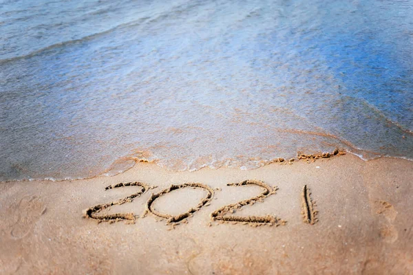 Happy new year 2021 text by the sea. Selective focus. Abstract background photography of the approaching New Year 2021 and the outgoing 2020