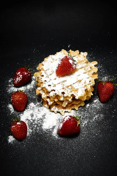 Koyu arkaplanda taze çilekli gevrek tatlı waffle..