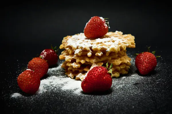 Crispy zoete wafels met verse aardbeien, op een donkere achtergrond. — Stockfoto