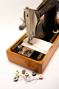 Dikiş makinesi ve beyaz arkaplandaki parçalar