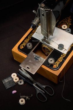 Dikiş makinesi ve koyu arkaplandaki parçalar