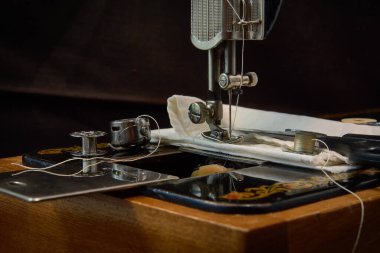 Dikiş makinesi ve koyu arkaplandaki parçalar