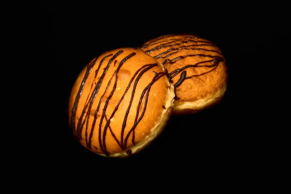 Delicate donuts with chocolate filling on a black background. — Stock Photo, Image