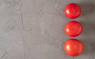 Domates sırası. Üç domates. Uzayı kopyala Mesaj için yer. Somut bir geçmiş. Ayrı domatesler. Taze ve sağlıklı