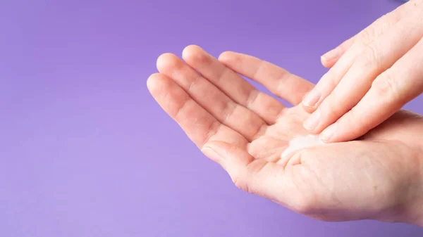 Moisturize hands with lotion. Woman applying moisturizing cream on hands. Body care. Isolated. Hand massage.