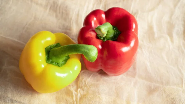 Peppers at home. Soft fabric. Bright vegetables Yellow and red bellpeppers. Light background Appetizing raw ripe peppers — Stock Photo, Image