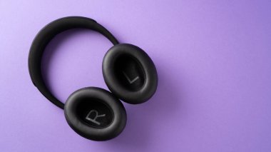 Her zaman müziğini dinle. Gençler için en iyi hediye. mor arkaplanda siyah kablosuz kulaklık.