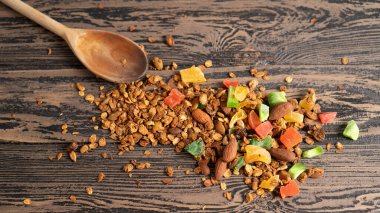 Taşralı sabah sağlıklı yiyecekler. Renkli ve parlak bir arka plan. Fındıklı tatlı taneler ve kahverengi ahşap masada meyveler.