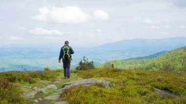 Sırt çantalı bir adam dağlarda yürüyor. Ukrayna dağları. Yerel dağlarda aktif eğlence..