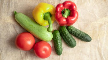 Yaz sebzeleri. Olgun sarı ve kırmızı dolma biber, salatalık, domates, kabak. Yumuşak kumaş