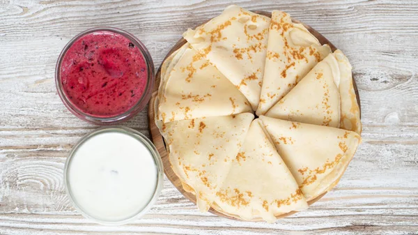 Goldene französische Crêpes serviert mit Sauerrahm und Eis im Glas zum Frühstück auf weißem Holztisch — Stockfoto