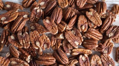 Beyaz ahşap masaya saçılmış ceviz cevizleri. Sağlıklı sonbahar yemeklerinin geçmişi. Boşluğu kopyala