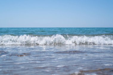 Küçük deniz dalgalarının seçici odak noktası. Parlak açık mavi ve beyaz dalga. Deniz meditasyonunun duvar kağıdı. Dinlen, sakinleş..
