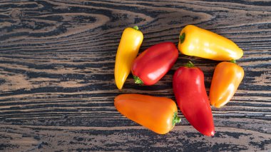 Farklı renklerde küçük dolmalıklar. Kırsal kahverengi ahşap masa üzerinde kırmızı dolma biber.