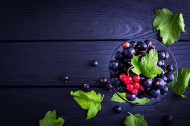 Koyu renkli ahşap arka planda yeşil frenk üzümü yaprakları. Frenk üzümü ve yeşil yapraklı arka plan. Frenk üzümü. Yakın plan.