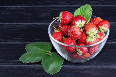 Koyu ahşap arka planda taze kırmızı çilekler. Metin için yer