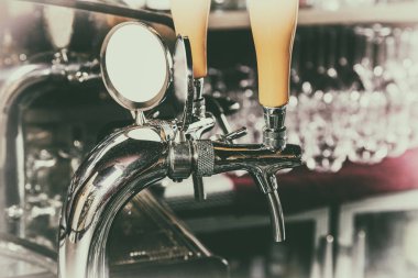 Modern bir barda bira fıçıları için krom musluklar. Bira makinesi detayı, bira dağıtıcısı, yakın çekim, seçici odak, retro tarzı