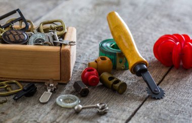 Dikiş kıskaçları, kıskaçlar ve eski ahşap yüzeydeki düğmeler için aksesuarların yaratıcı görüntüsü. seçici odak