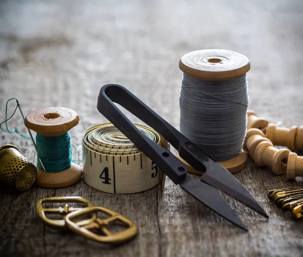 Creative image of seamstress ribbon tools, thimble and scissors for sewing on an old wooden surface. Concept. Selective focus. Retro style