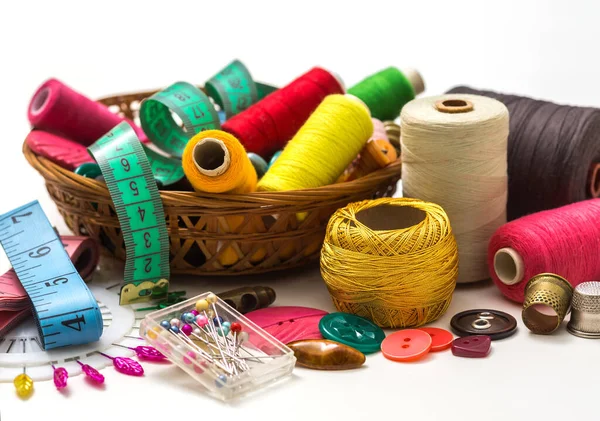 Sewing accessories for handmade sewing on a white background a spool of thread, scissors, buttons. Set for needlework.