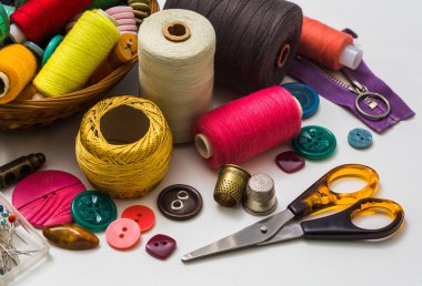 Beyaz arka planda el yapımı dikiş aksesuarları, bir makara, makas, düğmeler. Dikiş seti. Yukarıdan görüntüle