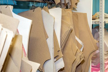 Dikiş dikmek için mukavva desenler bir dikiş fabrikasının iç duvarında asılı. Endüstriyel kıyafet üretimi, çok sayıda kağıt dikiş tasarımı