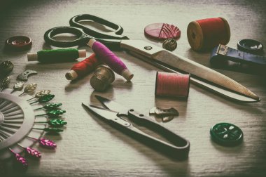 Dikiş işi için çeşitli aksesuarlar. Kumaş ve iplik makaraları, makas ve yüksük için dikiş malzemeleri. Retro tonin