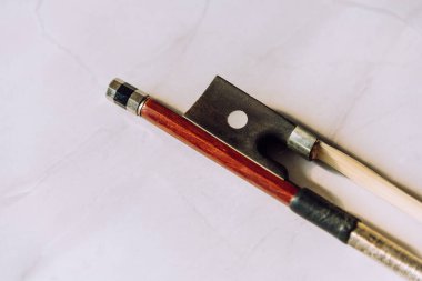 Topuk, ceviz ve vida keman yayının ön planında beyaz mermer arka planda. Seçici odak.