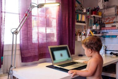 Küçük çocuk kucağında video seyrediyor