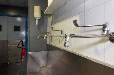 Ameliyathane koridorunda cerrahi el yıkama yığını.