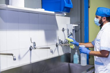 Bir hastane çalışanının ameliyat odasını temizlerken çekilmiş konsept fotoğrafı.