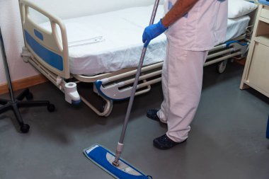 Hasta odasını temizleyen bir hastane çalışanının kavramsal fotoğrafı.