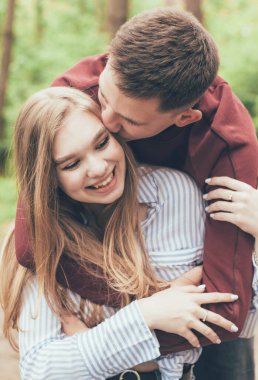 Adam ormanda kıza sarılıp öpüyor.