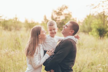 Eşofmanlı aile sarılıyor ve gülüyor.