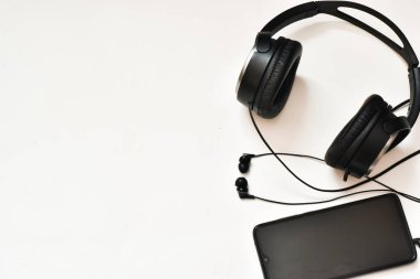 Kulaklık ve cep telefonu beyaz bir arkaplanda izole edilmiş..