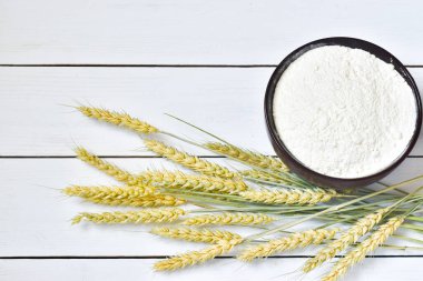 Beyaz ahşap arka planda un pişirmek ve buğday kulakları. düz alan, üst görünüm, kopyala boşluk.