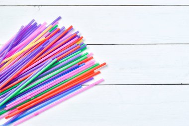 Pipet, tüp falan iç. Renkli boruların üst görüntüsü. Beyaz ahşap arka planda çevre dostu plastik pipetler.