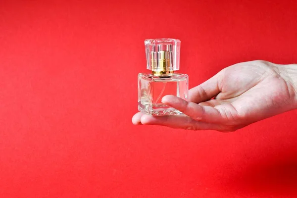 Frasco Perfume Una Maqueta Mano Femenina Sobre Fondo Rojo Primer —  Fotos de Stock