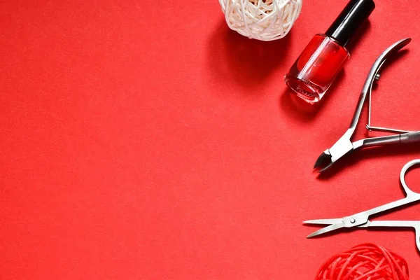 Manicure set and nail polish on a red background. Concept of beauty, manicure.