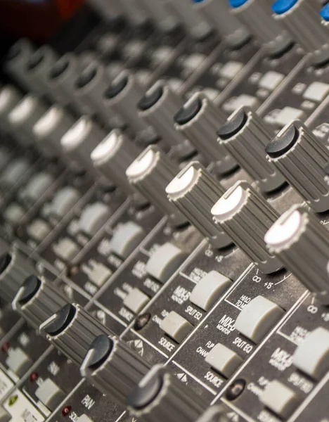 Closeup of audio mixing console. Shot of shallow depth of field. Audio studio work.