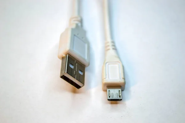 Old and used USB cable type microusb isolated on white background. Shot of grey data plastic information transfer cord.