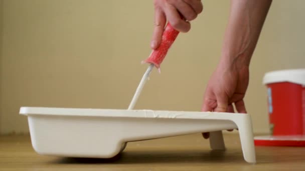 Close-up shot of a roller picking up paint from a plastic tub. Footage. Home renovation and renovation concept. — Stock Footage Close-up shot of a roller picking up paint from a plastic tub. Footage. Home renovation and renovation concept. Video Clip