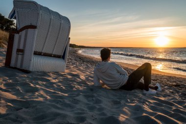 Gün batımında Baltık Denizi kıyısında bir sahil