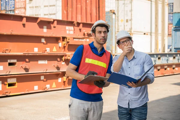 Foreman and dock worker staff working checking at Container cargo harbor holding clipboard. Business Logistics import export shipping concept.