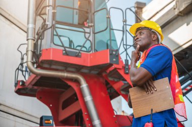 Kara ustabaşı konteynır kargo limanındaki vinç ve forklifti kontrol ediyor. Lojistik ihracat nakliye konsepti için Afrika rıhtımı erkek personeli.