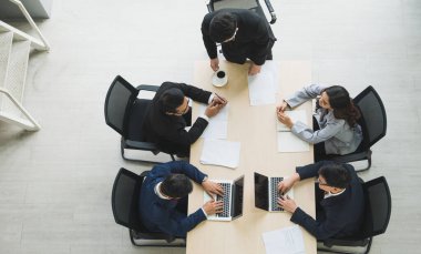 Asyalı iş adamlarının istatistik analizi takımının en üst görüşü. İş adamlarından oluşan bir ekibin yüksek açılı görüşü Toplantı Konferansı Kurumu Konsepti ofiste.